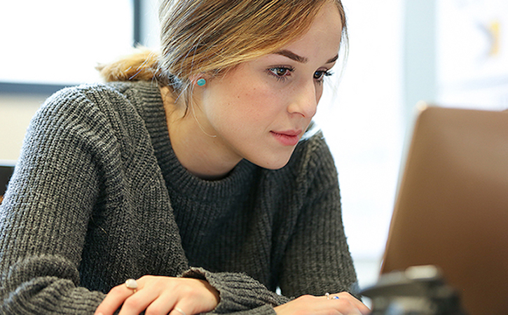 Deisgn student looking at laptop