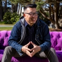 David Leroid sitting on a purple sofa on campus