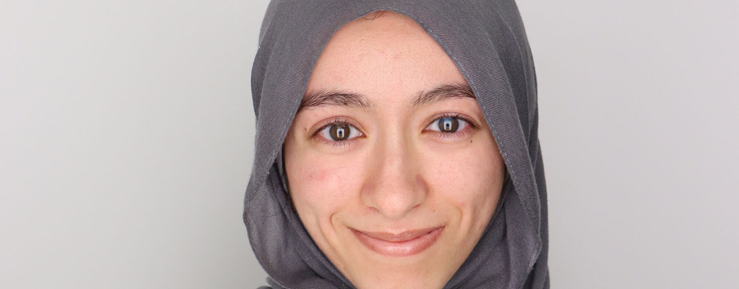 Tasnim Saada, MA Design Graduate Student, in grey hajib and white sweater