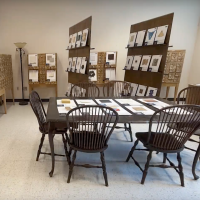 Photograph of the sustainable materials library. The photo shows a table with chairs, some drawer chests, and panels showcasing samples of sustainable materials.